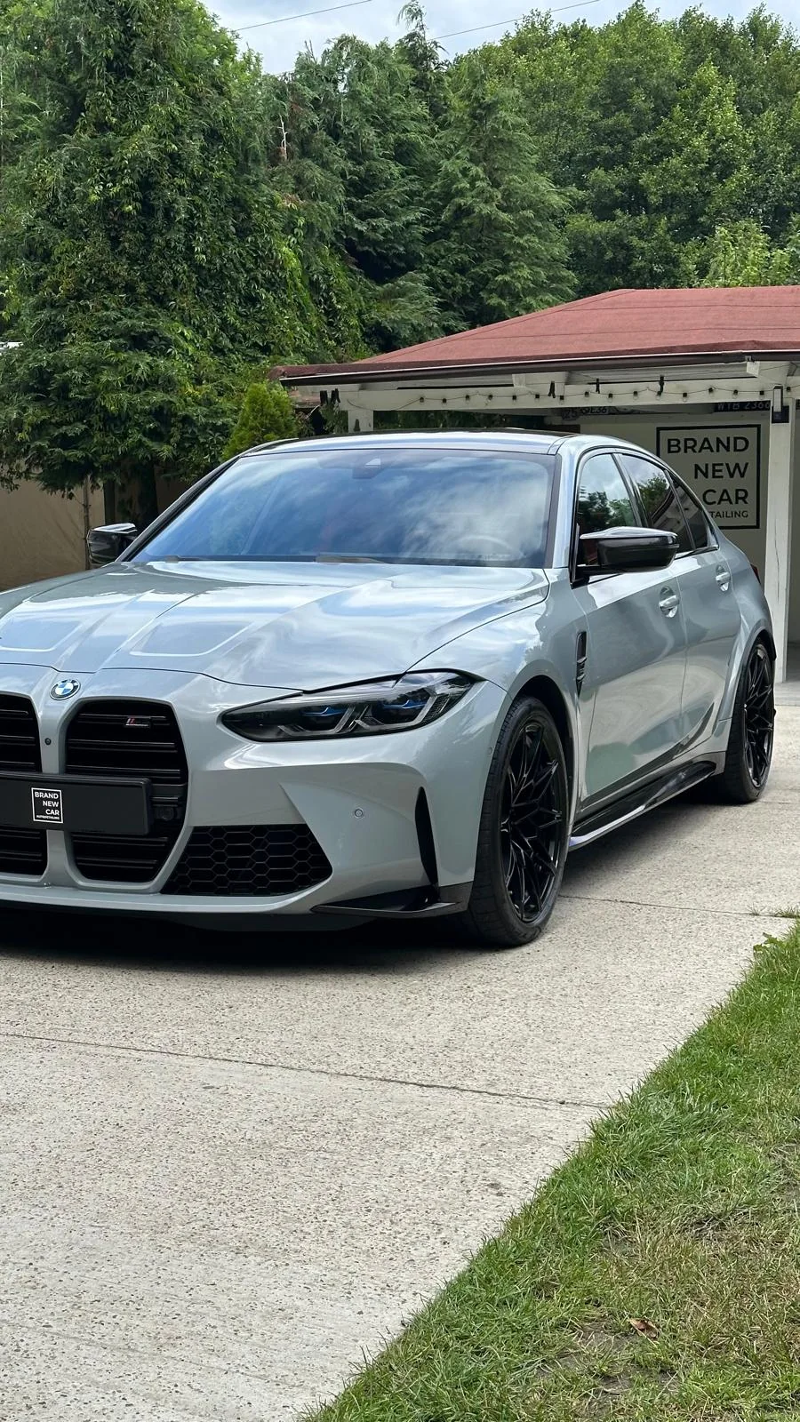 Light grey BMW M3 with black wheels outside the Brand New Car studio